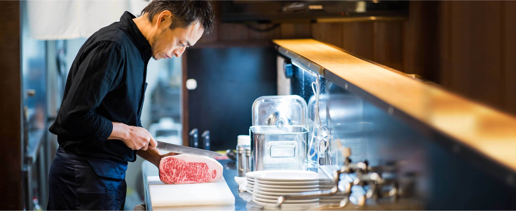 肉をカットする焼肉きっず店主