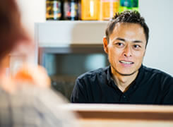 カウンター越しにお客さんと話をしている店主の写真